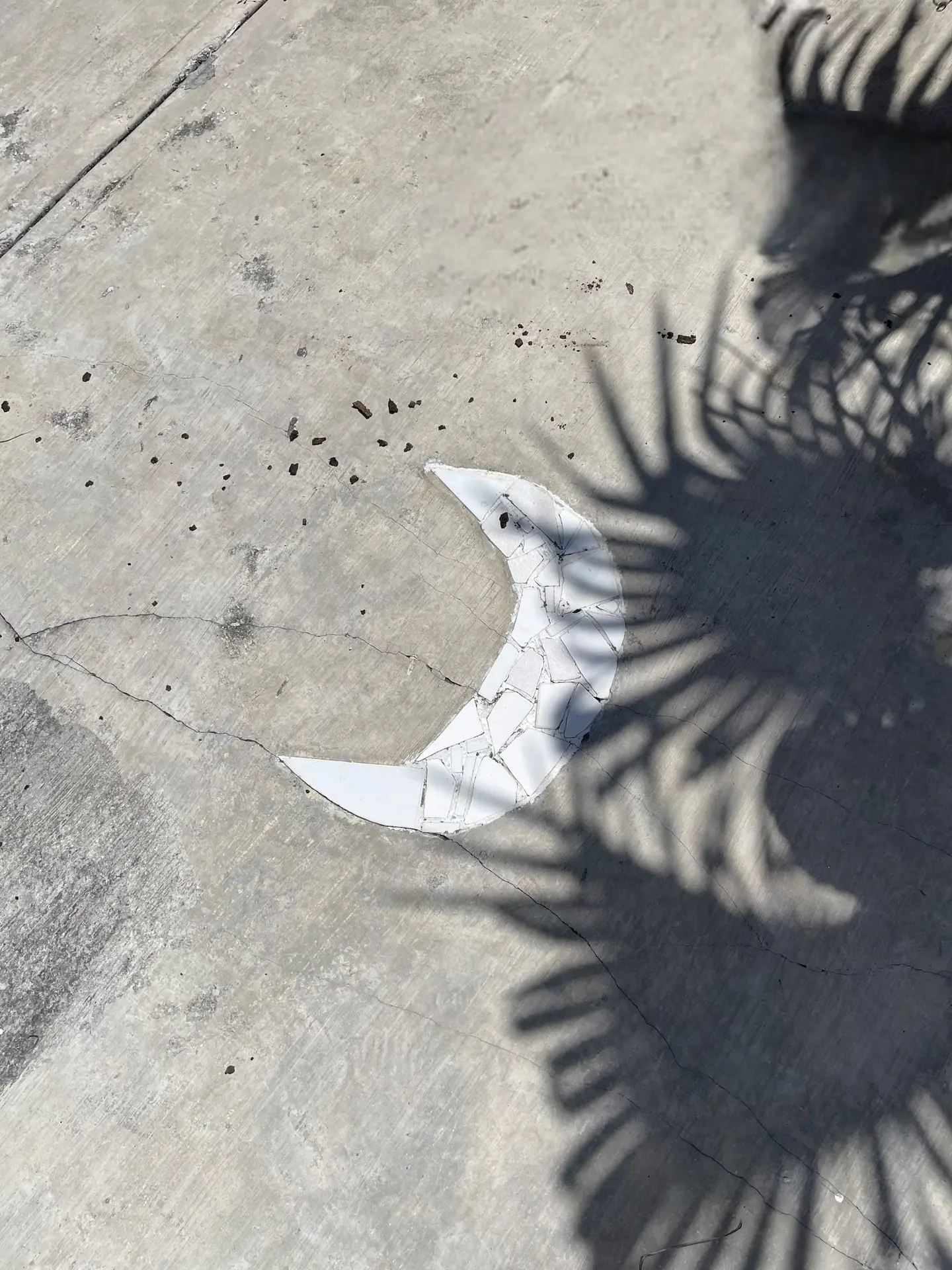 A white crescent moon inlaid in the original concrete driveway